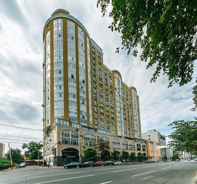 een groot hoog gebouw met auto's geparkeerd voor het bij Apartment Penthouse in Kiev