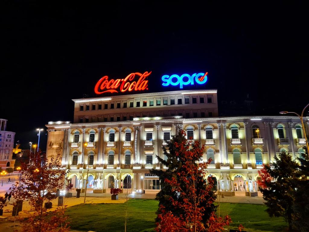 a building with a neon sign on top of it at MIKA Square in Skopje
