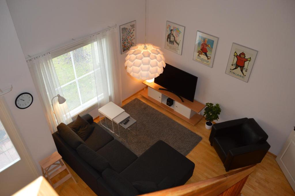 a living room with a black couch and a television at Apartment Vuokatin Taika 1 - Loppusiivous sisältyy hintaan in Vuokatti