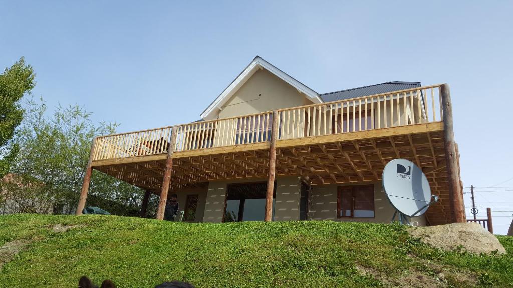 uma casa com um deque no topo de uma colina em Casa Franca em El Calafate