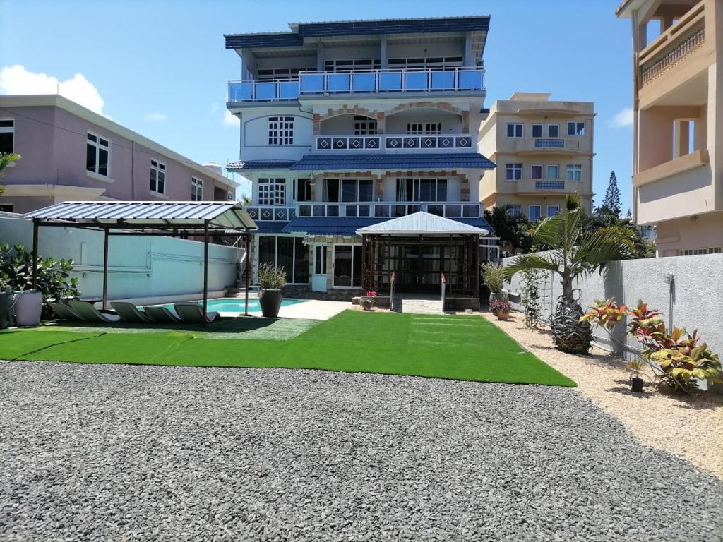 a large building with a lawn in front of it at Reviva Residence and Ayurveda Massage center in Blue Bay