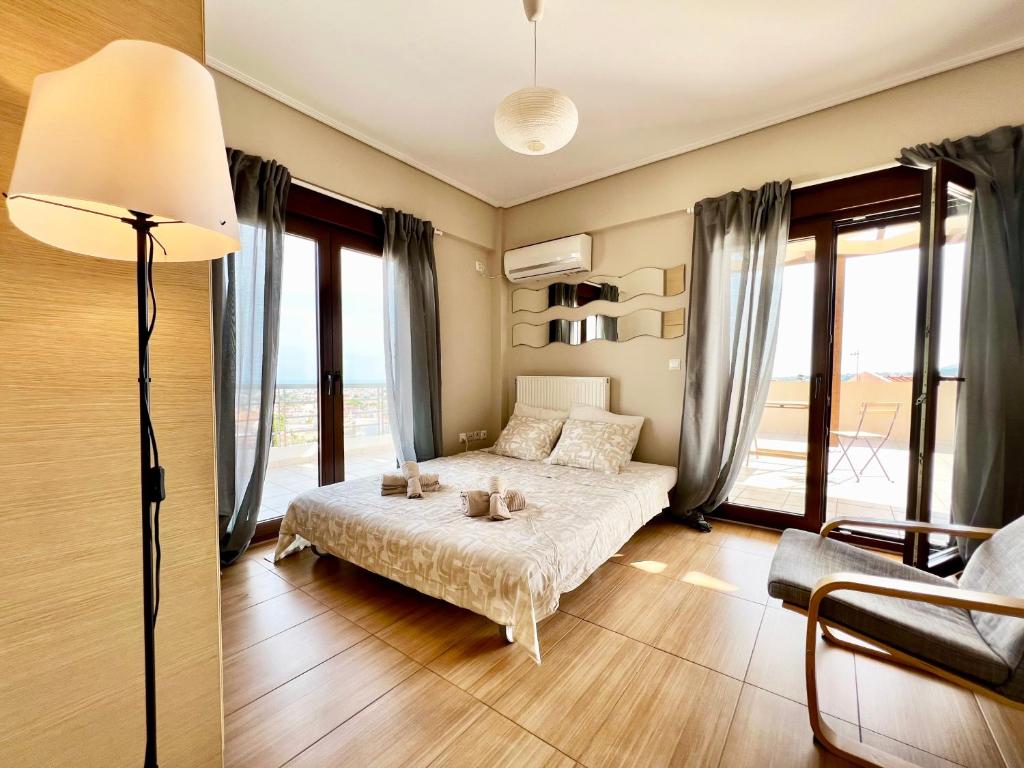 a bedroom with a bed and a lamp and windows at Sunrise Studio with unhindered view to the sea. in Nea Makri