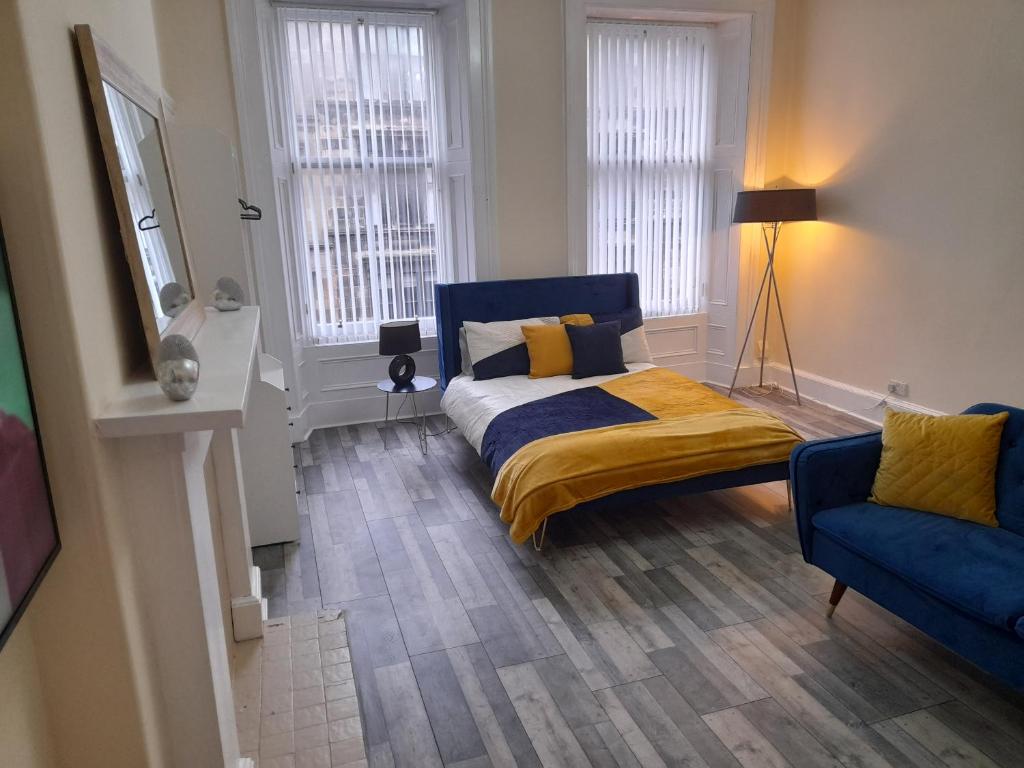 a bedroom with a bed and a blue chair at Traditional west end Glasgow in Glasgow