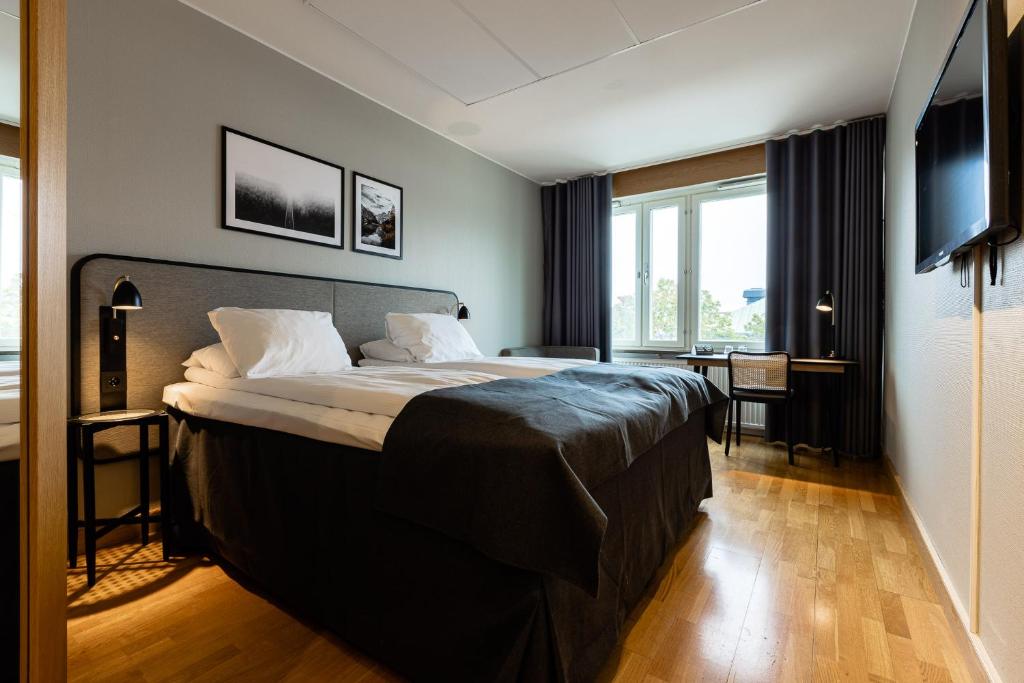 ein Schlafzimmer mit einem großen Bett und einem großen Fenster in der Unterkunft Clarion Collection Hotel Etage in Västerås