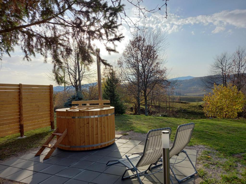 2 sedie e una vasca idromassaggio in legno su un patio di The House of Dunja a Rakovica