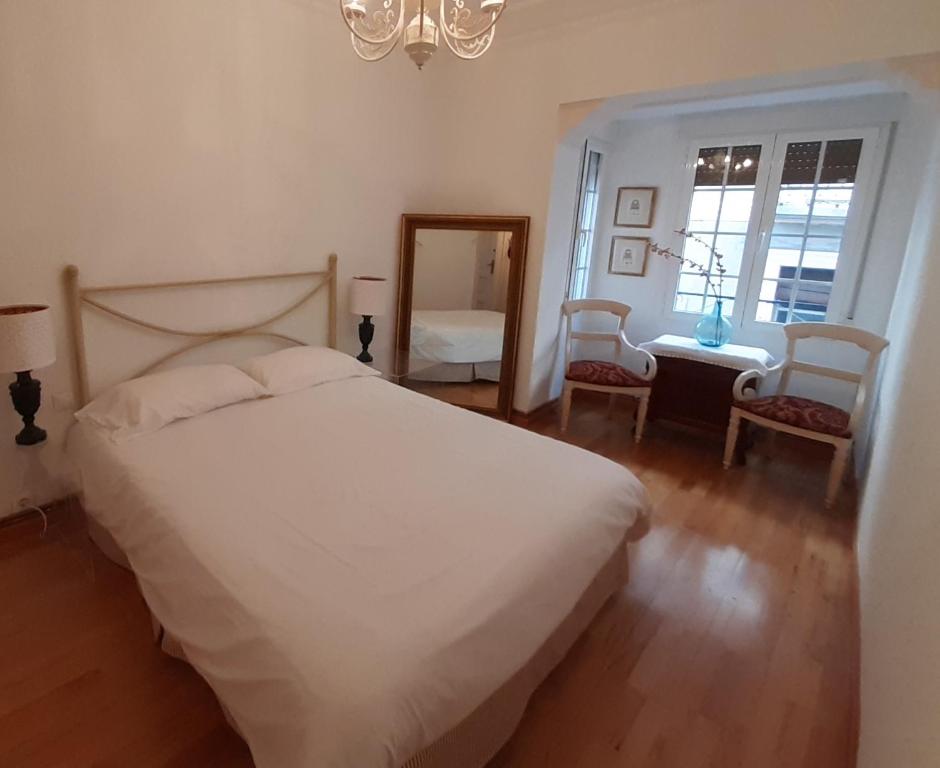 a bedroom with a white bed and a mirror at Acogedor piso en pleno centro de Zaragoza in Zaragoza