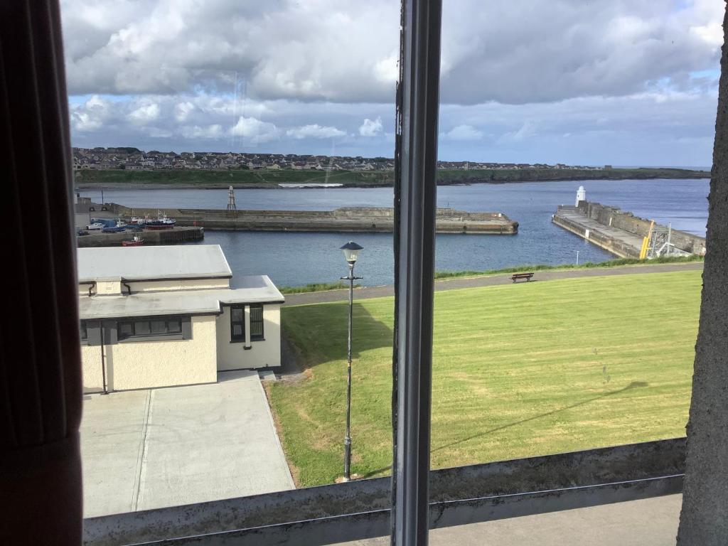 a view of a body of water from a window at Harbour View in Wick