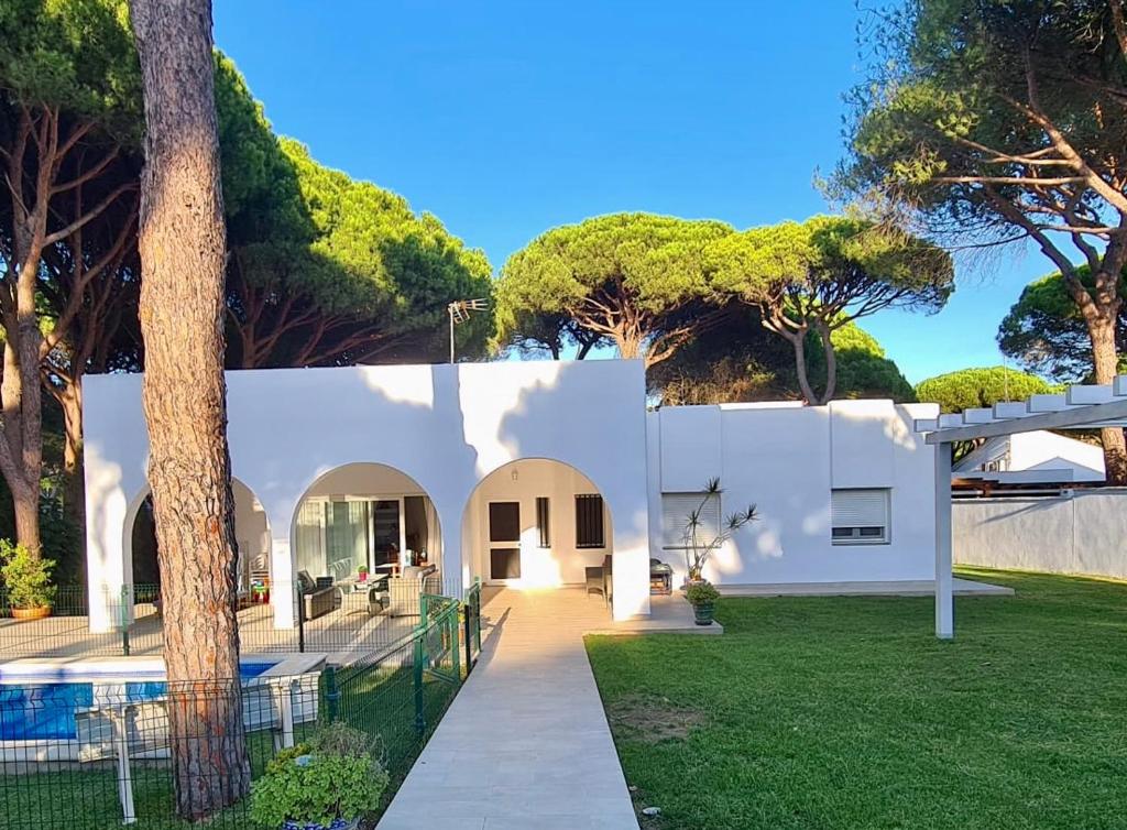 a white house with a yard with a pool at Roche Pinos Verdes in Roche