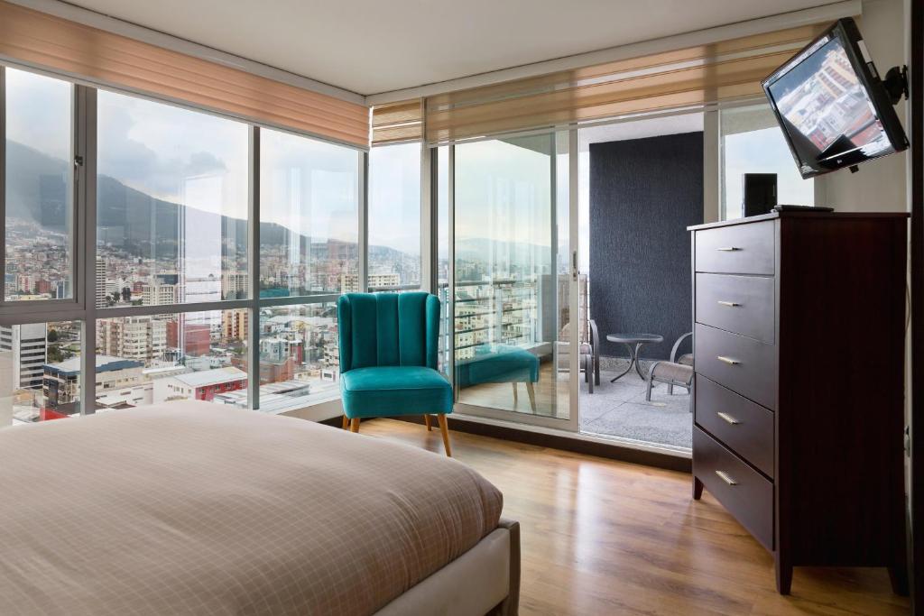 a bedroom with a bed and a large window at Olympus Apartments in Quito
