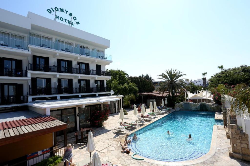 uma piscina em frente a um hotel em Dionysos Central em Pafos