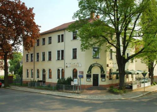 um grande edifício branco no lado de uma rua em Pension Lindenhof em Dresden