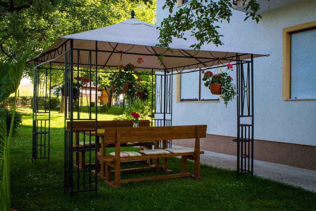 a gazebo with a bench in the grass at Rooms Marijana Obrovac in Slunj