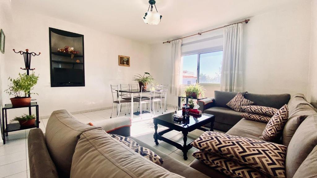 ein Wohnzimmer mit einem Sofa und einem Tisch in der Unterkunft Modern & Sunny new appartement 2 rooms in Rabat centre - Hay Riad in Rabat