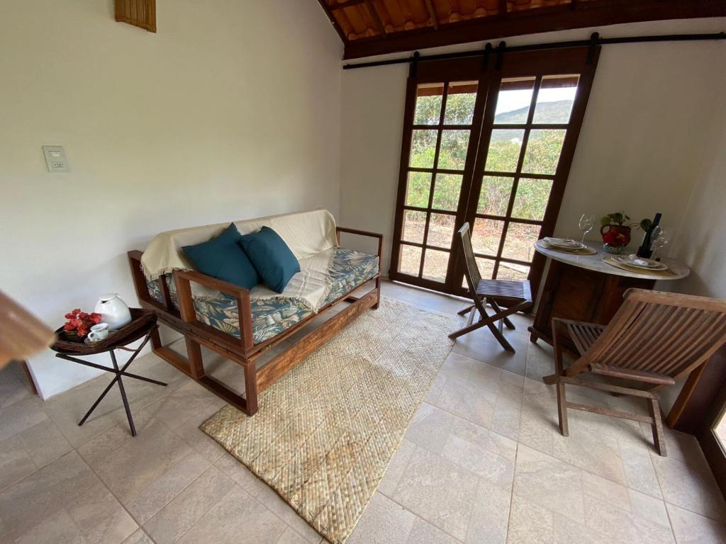 ein Wohnzimmer mit einem Sofa und einem Tisch in der Unterkunft Manacá Chalés do Vale in Vale do Capao