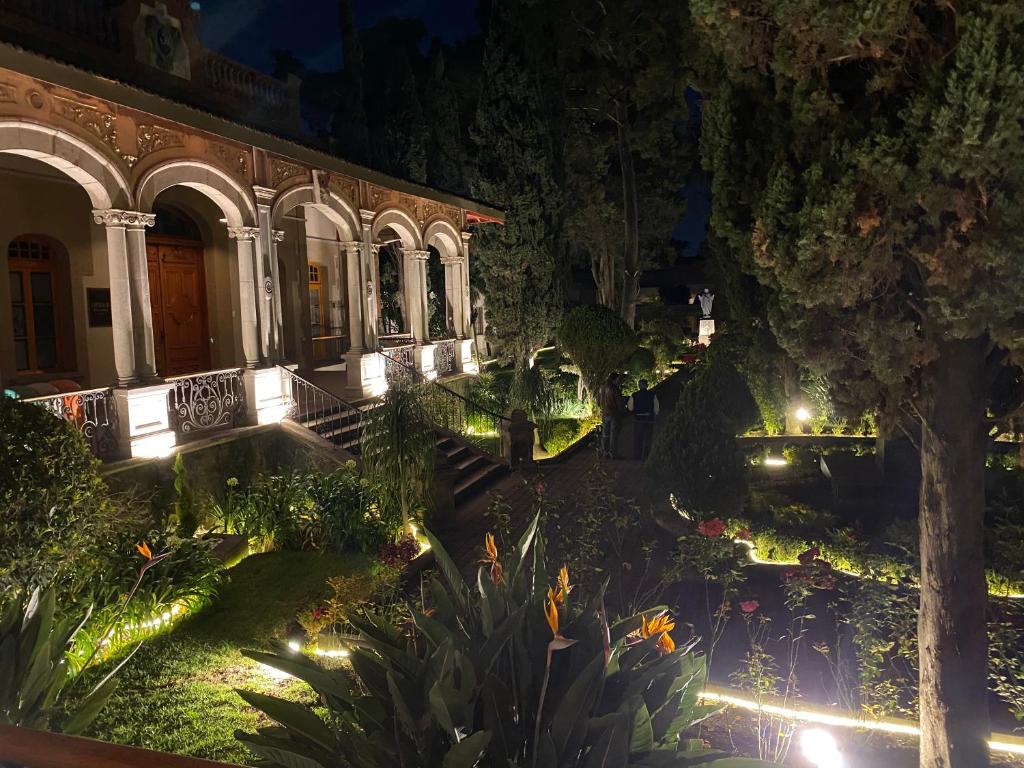 un edificio con jardín por la noche con luces en Hotel Express Quinta Soledad, en Ciudad de México