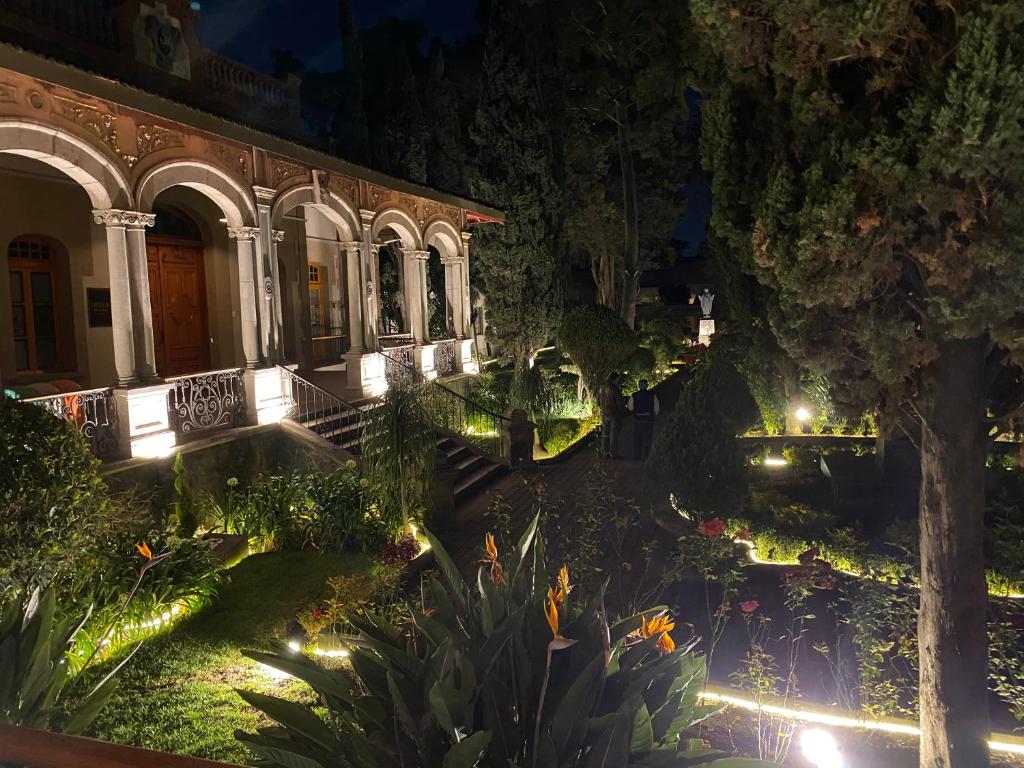 - un bâtiment avec un jardin éclairé la nuit dans l'établissement Hotel Express Quinta Soledad, à Mexico