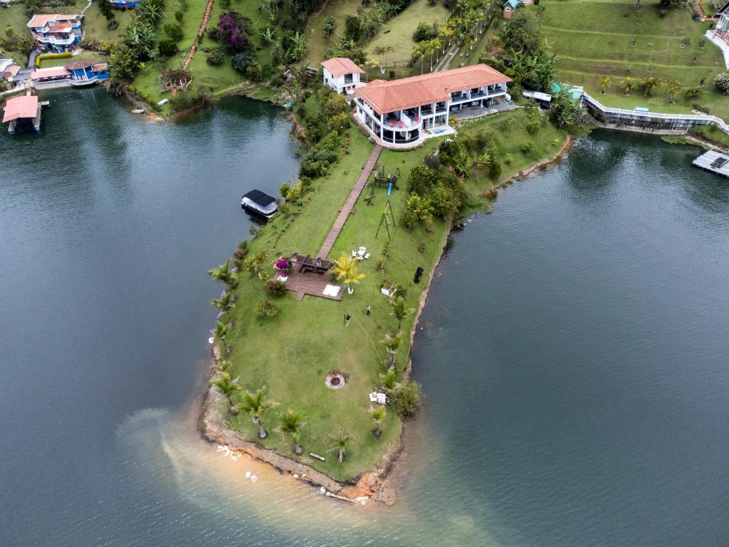 an island in the water with a house on it at Jordan Hotel Boutique in Guatapé