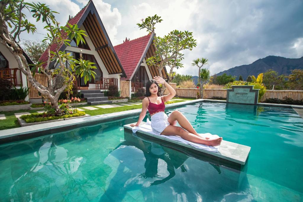 a woman sitting on a raft in a swimming pool at Oemah Batur in Kintamani