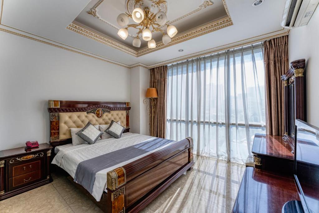 
a bedroom with a large bed and a large window at Happy Land Hotel in Ho Chi Minh City
