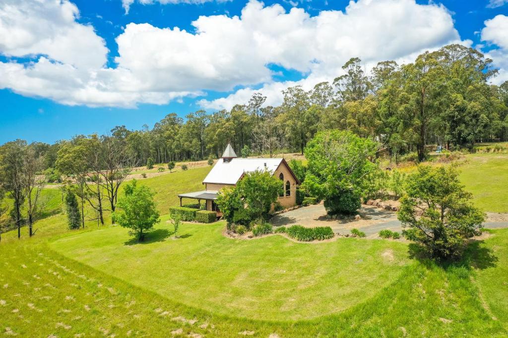 an aerial view of a house on a grassy hill at Clarendon Forest Retreat in Possum Brush