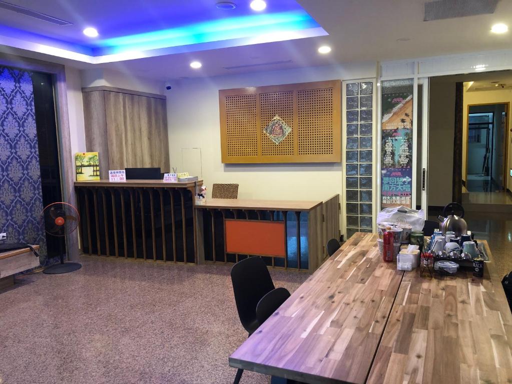 a conference room with a wooden table and blue lights at Hai Gang Yuan Homestay in Kenting