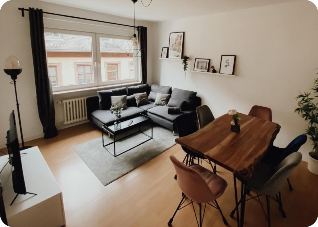 a living room with a table and a couch at Attraktive 3-Zimmerwohnung - Zentrum Würzburg & nähe Bahnhof in Würzburg