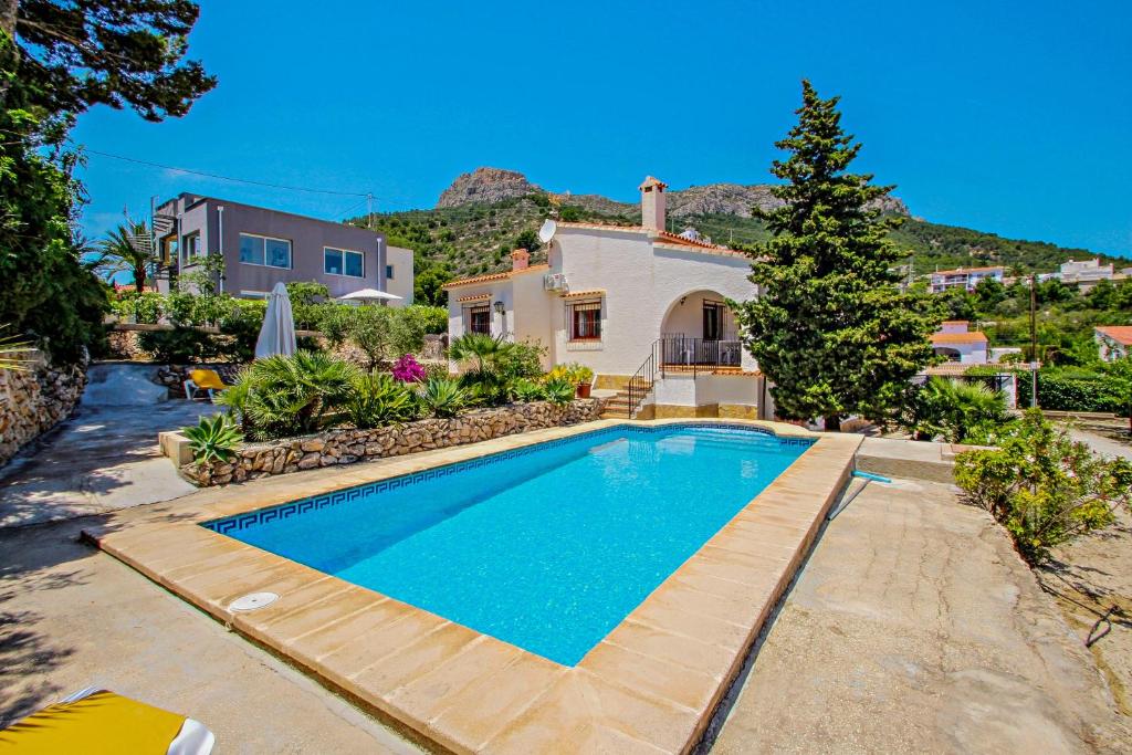a swimming pool in front of a house at Laura-29A - pretty holiday property with garden and private pool in Calpe in Calpe