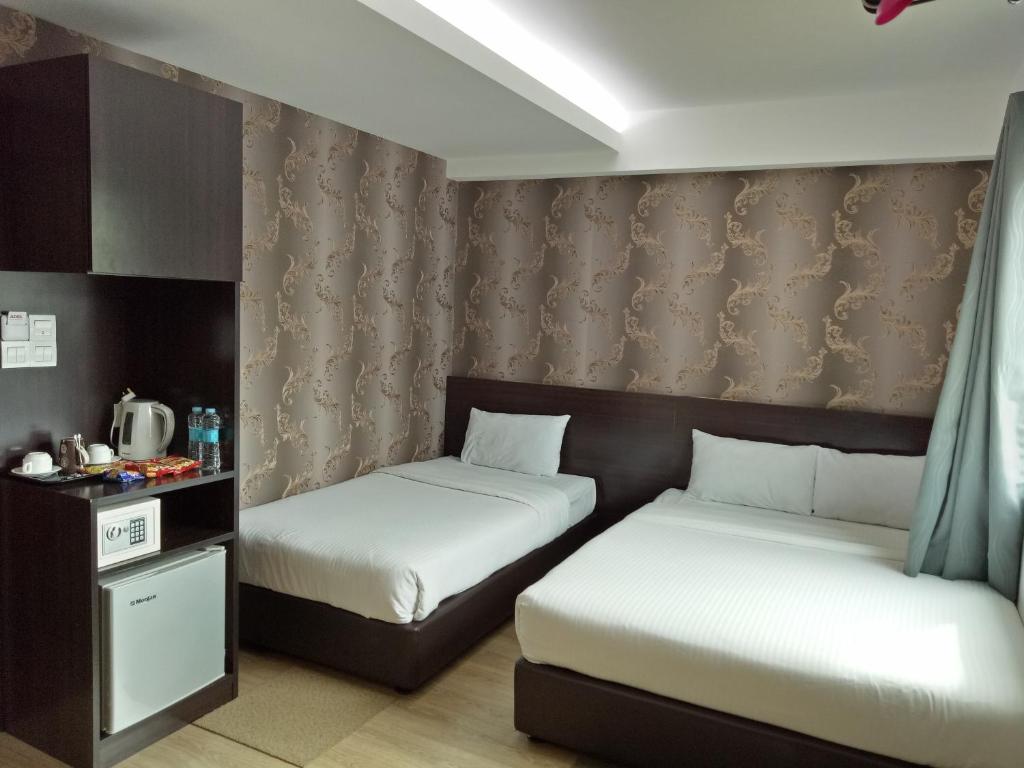een kamer met 2 bedden en een tafel en gordijnen bij 7 Hotel in Juru