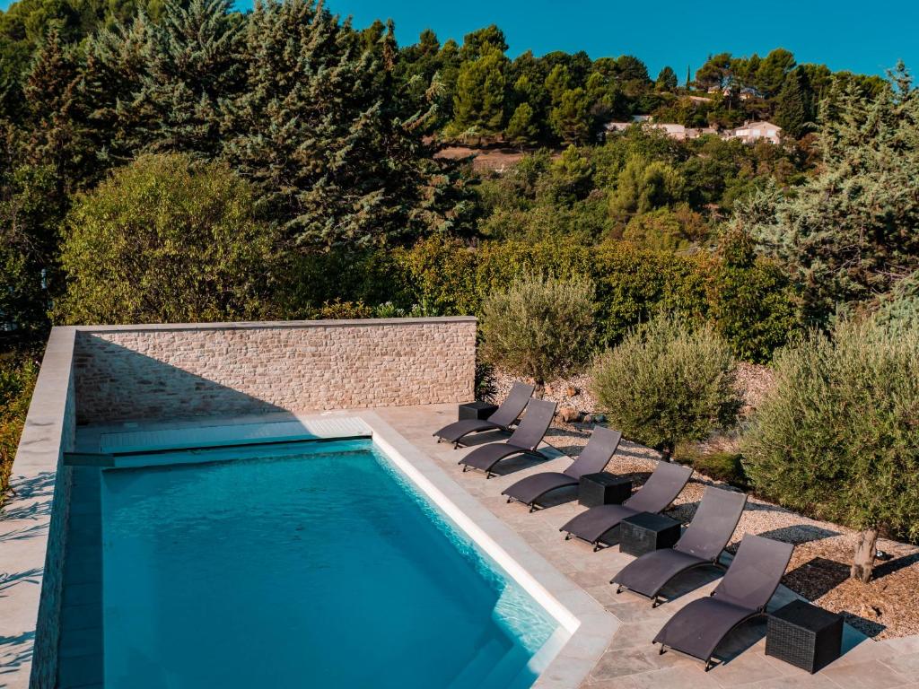 a swimming pool with lounge chairs next to a swimming pool at Le Petit Rossignol in Apt