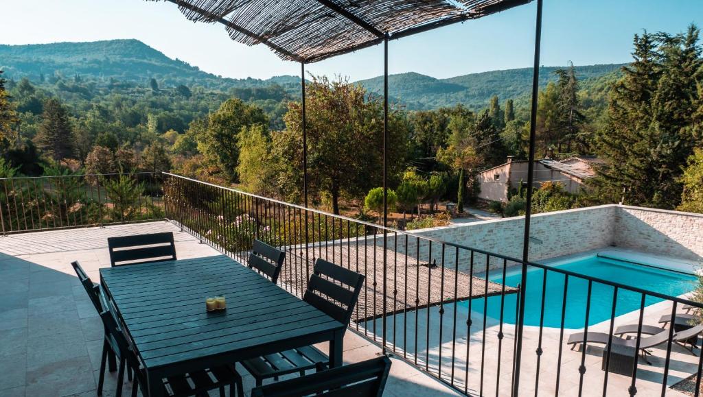 a patio with a table and chairs and a swimming pool at Le Petit Rossignol in Apt