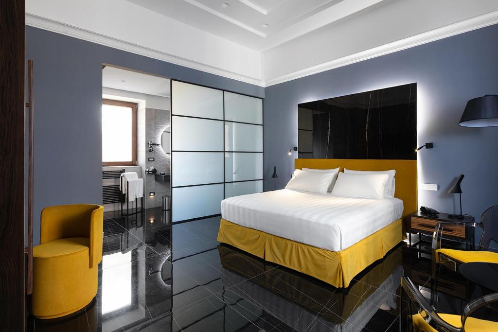 a bedroom with a king sized bed and a bathroom at Hotel Poerio 25 Boutique Stay in Naples