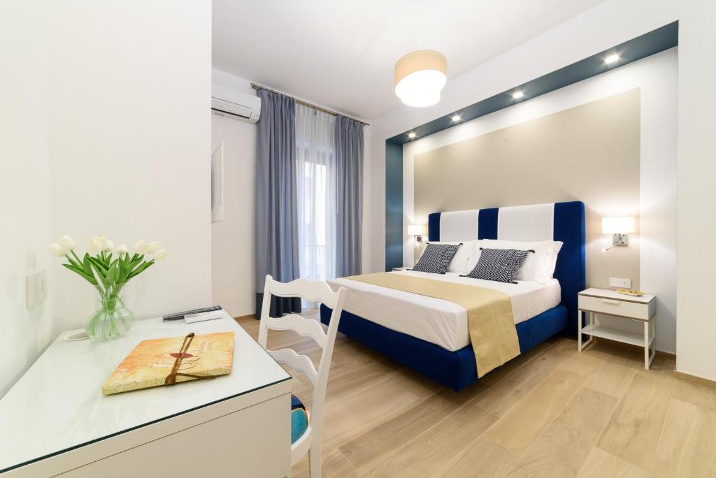 a bedroom with a bed and a desk with a table at La Maison du Grand Tour in Cava deʼ Tirreni