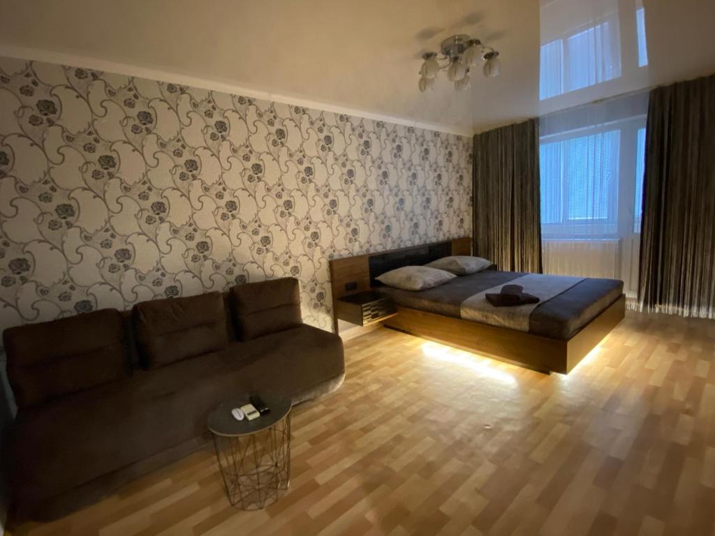 un soggiorno con un divano e un letto di 2 комнатная квартира, до 6 спальных мест(КБ-75,Ашан, Метро,Эпицентр) a Kryvyj Rih