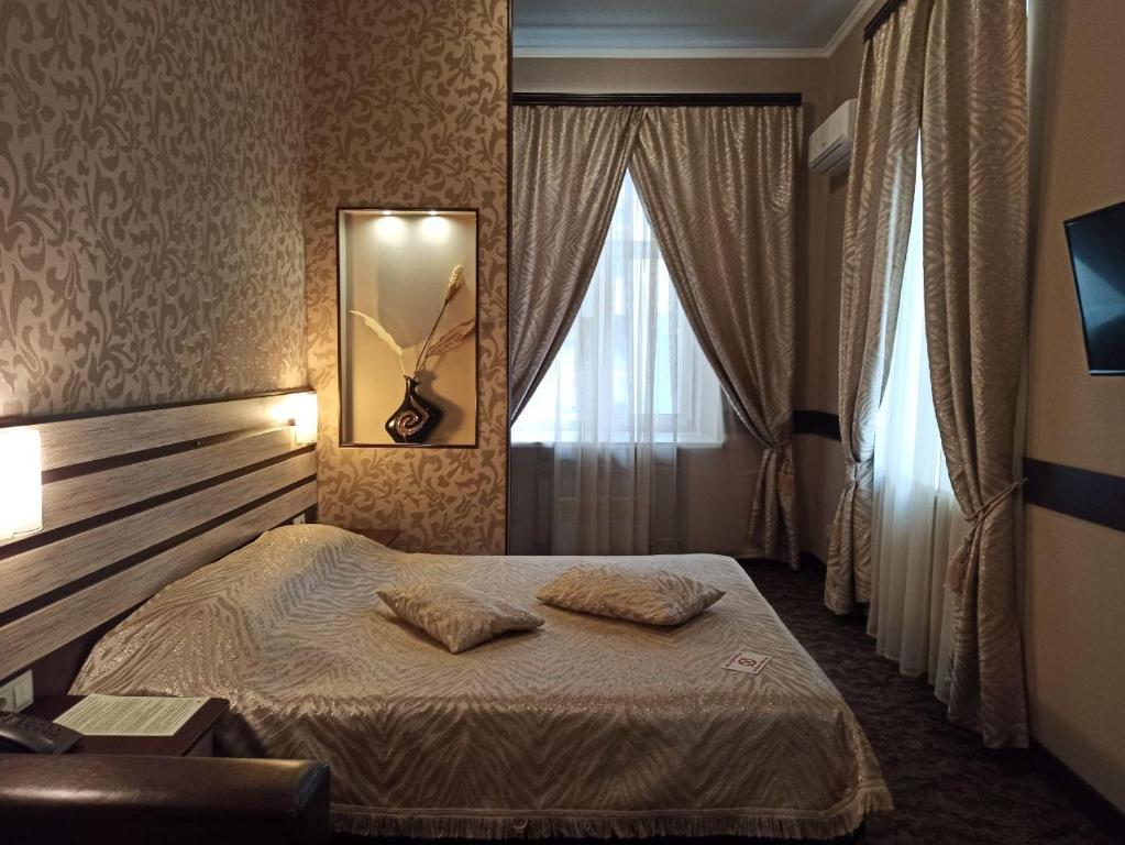 a bedroom with a bed and a mirror and a window at Classic Hotel in Kharkiv