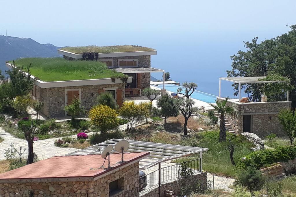 a house on a hill with a view of the ocean at Infinity Alinca in Karaagac