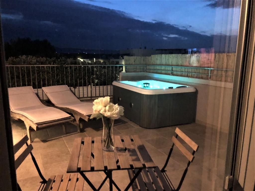 een balkon met een hot tub en een tafel en stoelen bij Bianca Dimora in Torre Canne