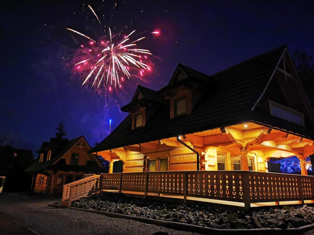 a house with fireworks exploding in the sky behind it at Chaty Misiagi in Poronin