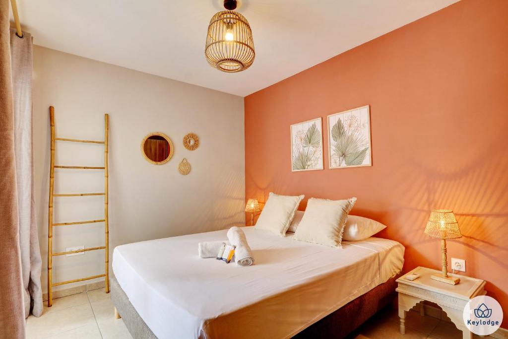 - une chambre dotée d'un lit avec un mur orange dans l'établissement T2 - Le Céladon - 3 étoiles - proche centre Saint-Denis, à Saint-Denis