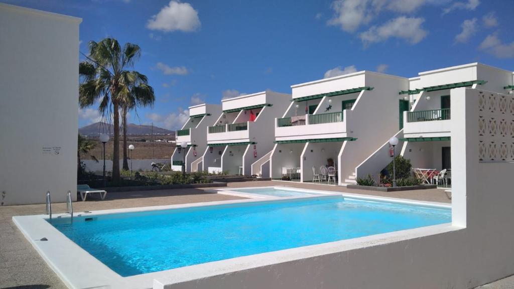 een zwembad voor een gebouw bij Apartamento Pocillos Mimosas in Puerto del Carmen