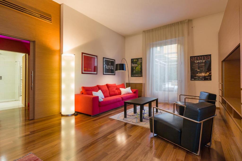 a living room with a red couch and a table at Arena Verona Centro in Verona