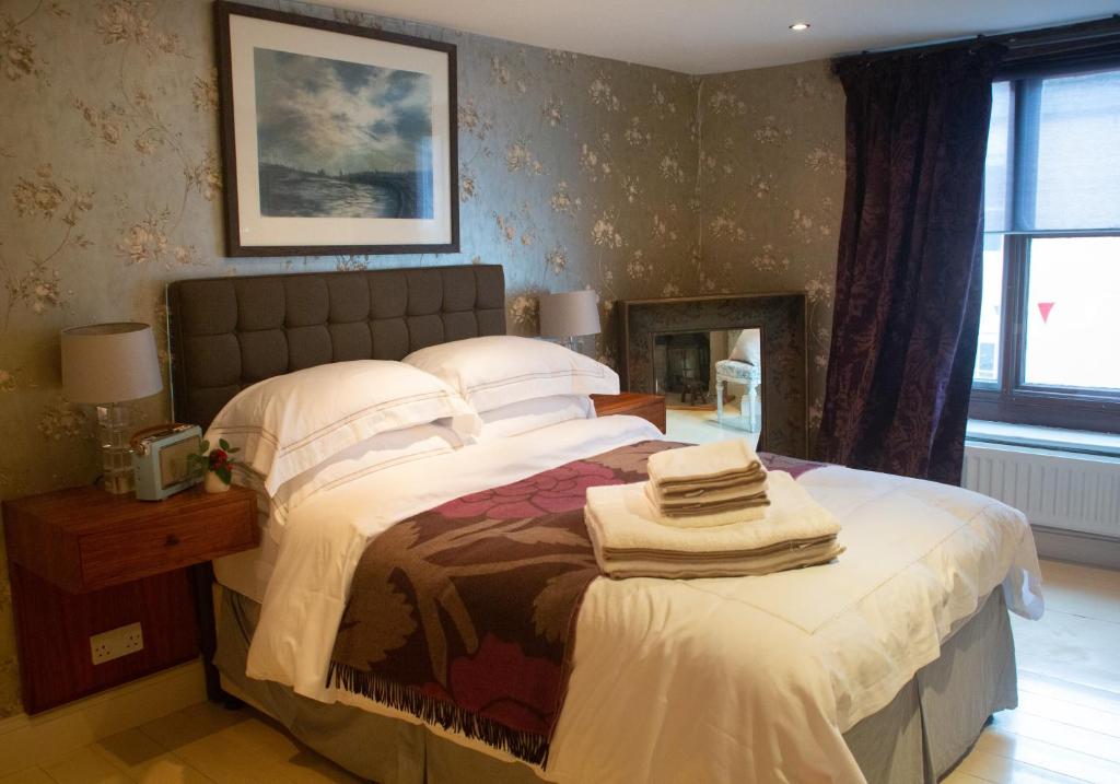 um quarto com 2 camas, uma mesa e uma janela em The Candlemakers em Hexham