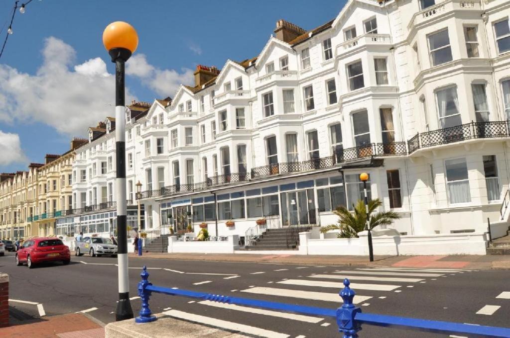 a row of white buildings on a city street at The Strand Hotel in Eastbourne