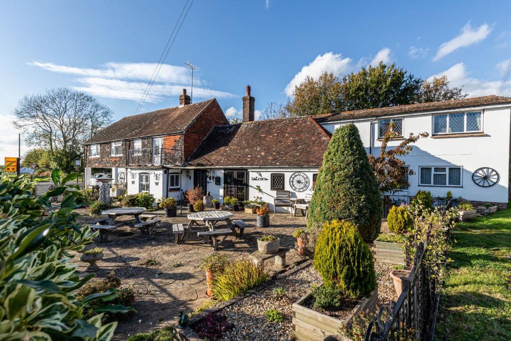 un pub avec un jardin en face d'un bâtiment dans l'établissement The Olde Forge Hotel, à Hailsham