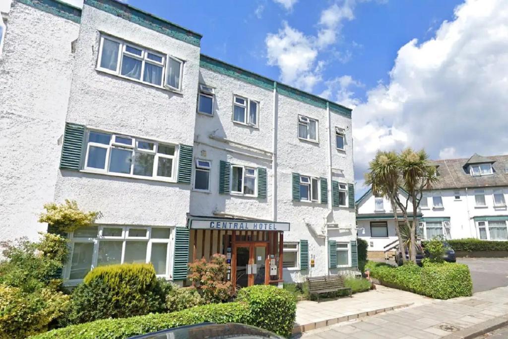 an apartment building with green shutters at Central Hotel Golders Green in London