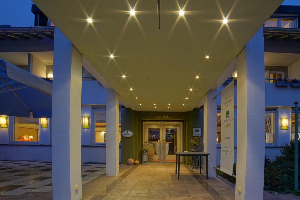 einen Flur mit Säulen und Leuchten an einem Gebäude in der Unterkunft Hotel zur Flüh in Bad Säckingen