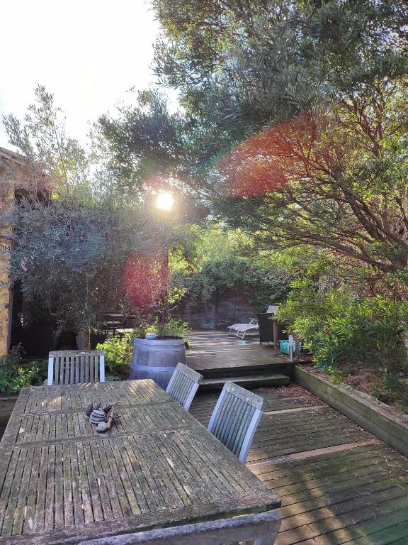 une table et des chaises en bois sur une terrasse en bois dans l'établissement Domaine Les Cascades, à Ribaute