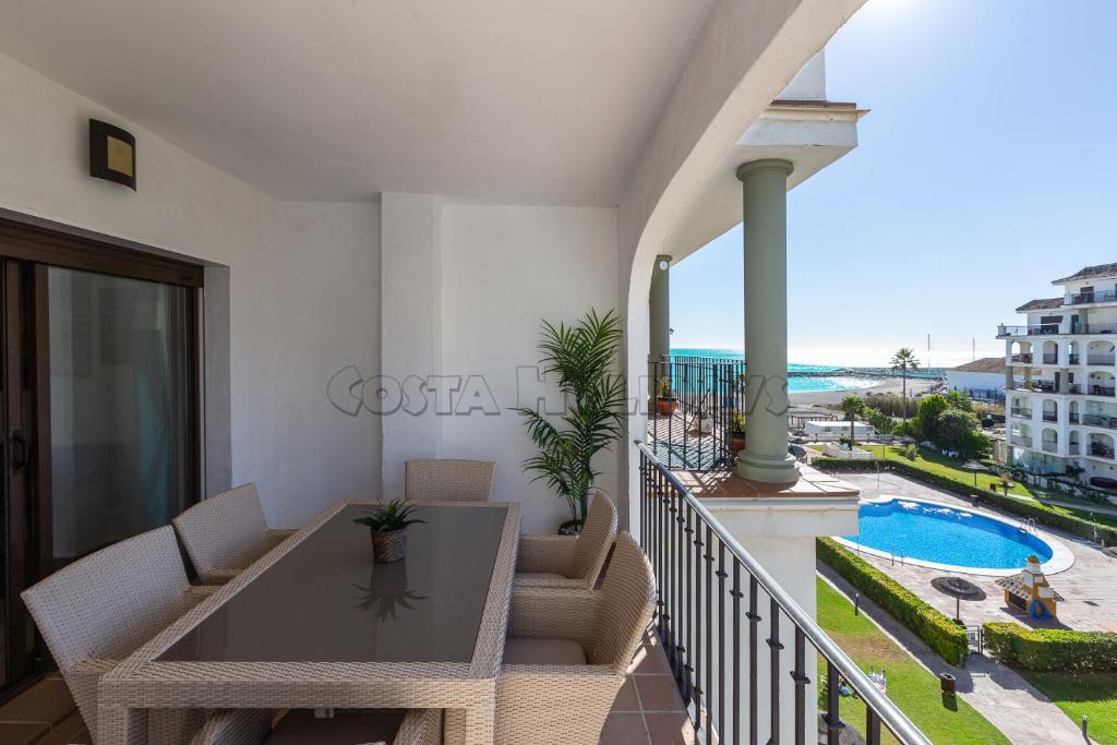 een balkon met een tafel en stoelen en een zwembad bij Marina duquesa836 in Castillo de Sabinillas