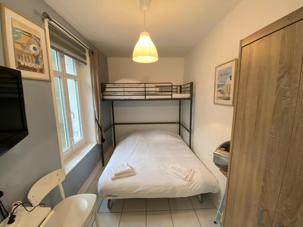 ein kleines Zimmer mit einem Etagenbett und einem Fenster in der Unterkunft Joli Studio proche plage et centre avec parking in Wimereux