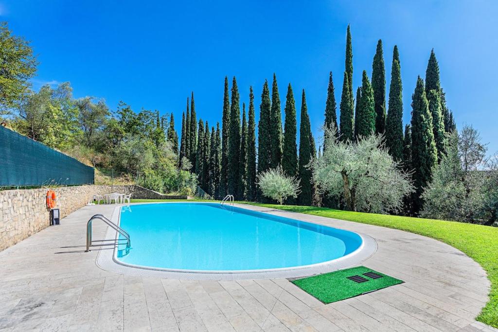 Una gran piscina en un patio con árboles. en Al Vittoriale 3 by Wonderful Italy, en Gardone Riviera