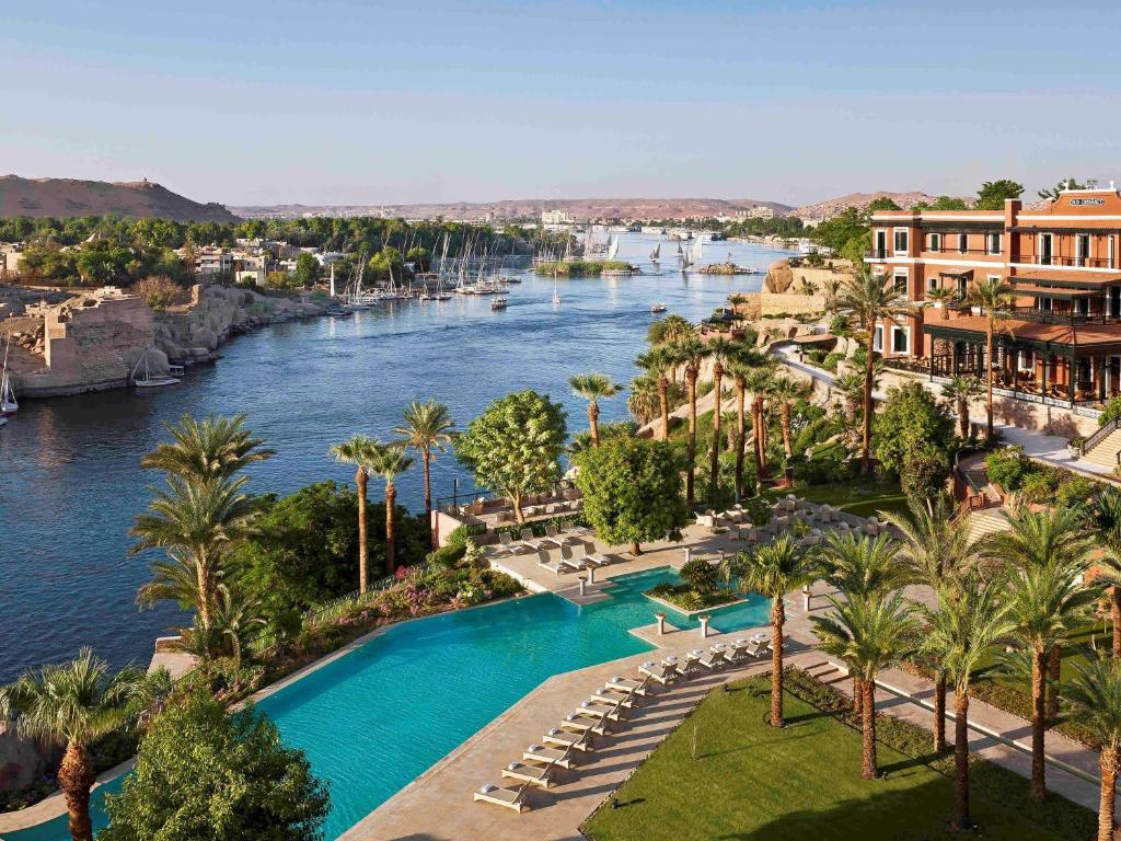 a large body of water with palm trees at Sofitel Legend Old Cataract in Aswan